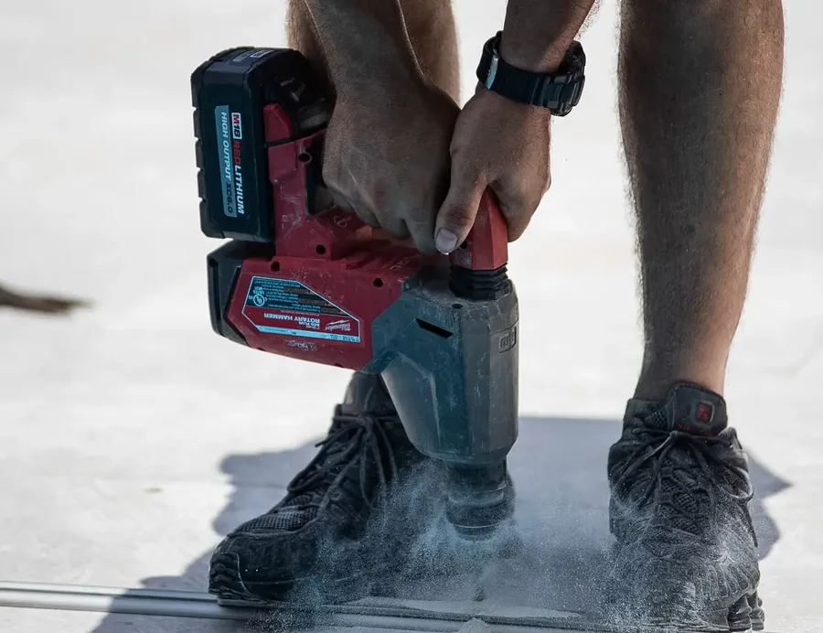 Certified Cover Dream installer using a rotary hammer to secure a Coverseal track