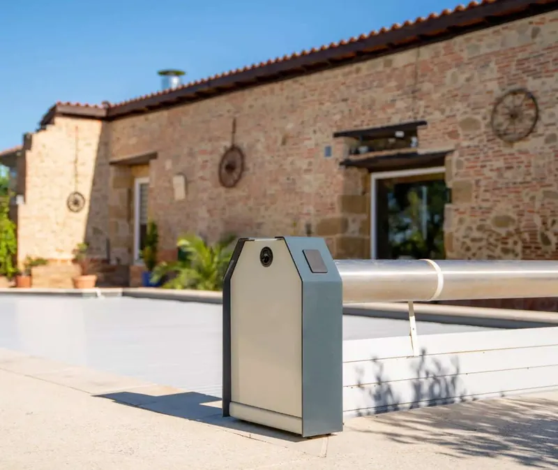 S-ROLL slatted automatic pool cover beside a stone house