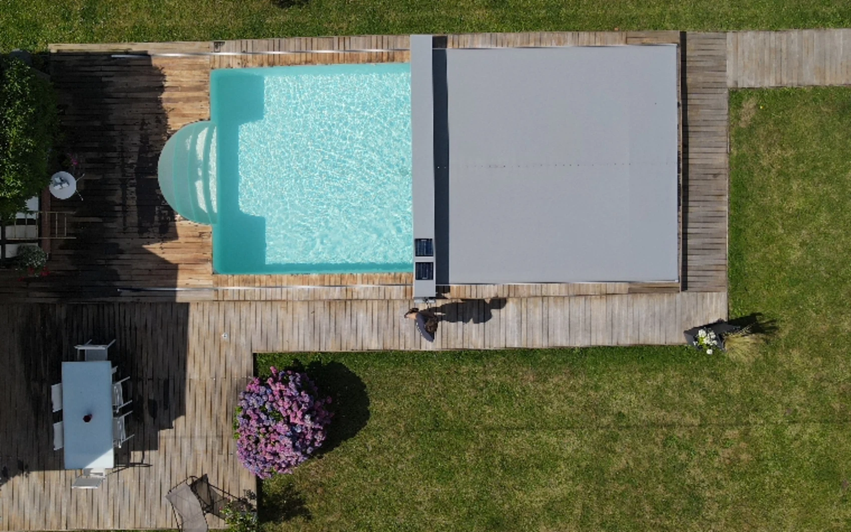 Aerial drone view of a Coverseal safety cover fully closed beside the open pool